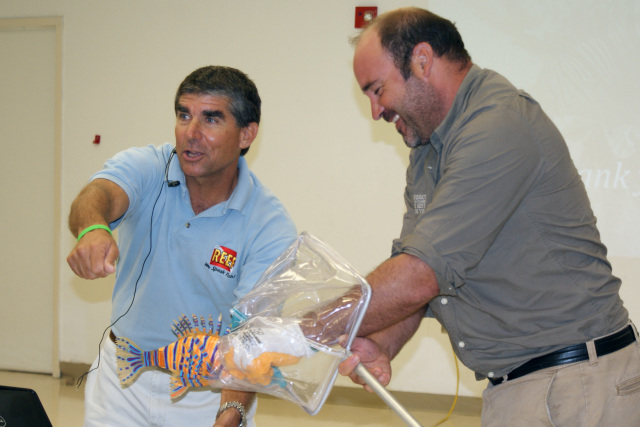 Lad Akins showing the audience how to properly handle a captured lionfish in San Juan